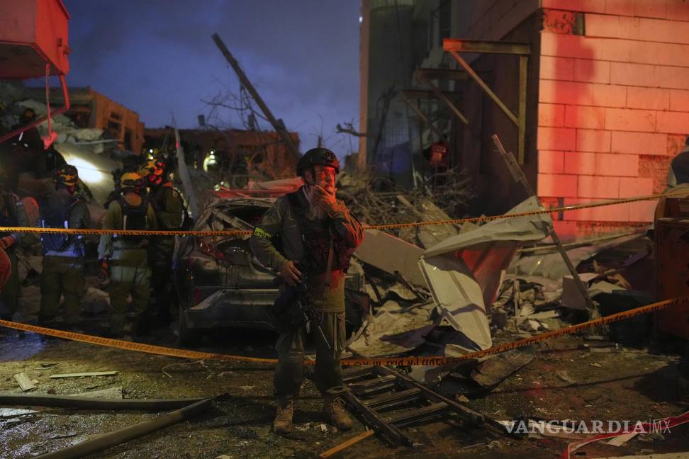 $!Las fuerzas de seguridad israelíes inspeccionan los edificios destruidos por un misil lanzado desde Irán, cerca de Tel Aviv, Israel.