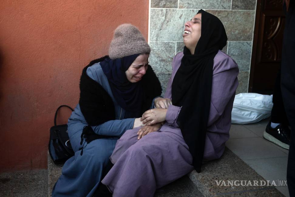 $!Dos mujeres palestinas lloran a sus familiares fallecidos en un bombardeo israelí sobre la Franja de Gaza, en el exterior de una morgue en Jan Yunis.