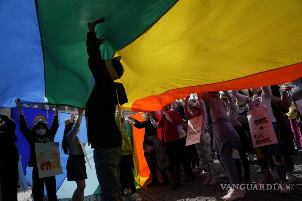 $!Niños juegan bajo una enorme bandera de la paz del arco iris durante la oración del mediodía del Ángelus del Papa Francisco en la Plaza de San Pedro en el Vaticano.