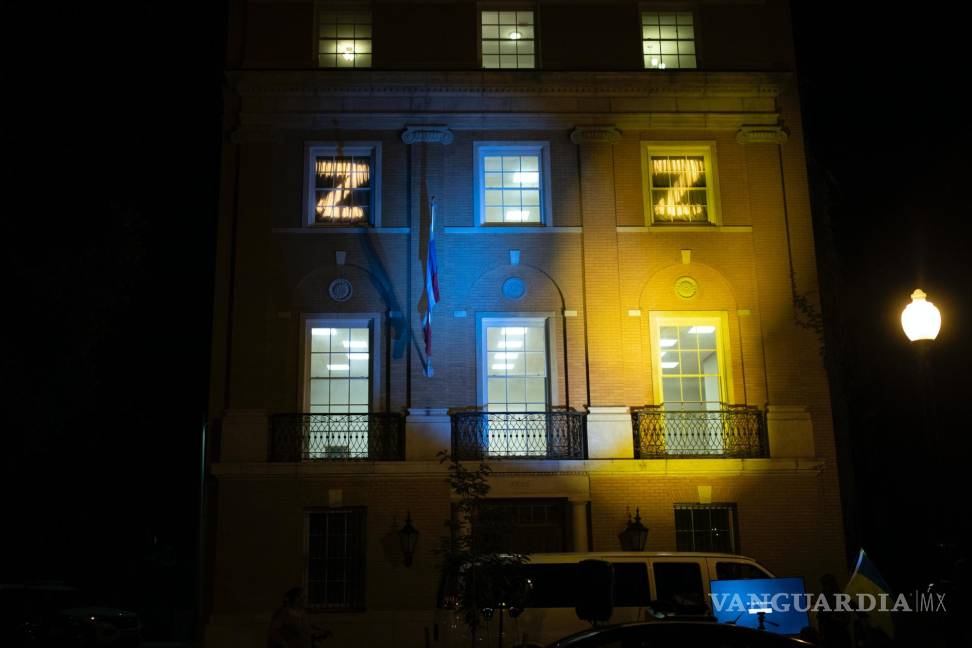 $!El personal de la embajada rusa muestra la letra “Z” en sus ventanas mientras los manifestantes proyectan los colores de la bandera de Ucrania en el edificio.