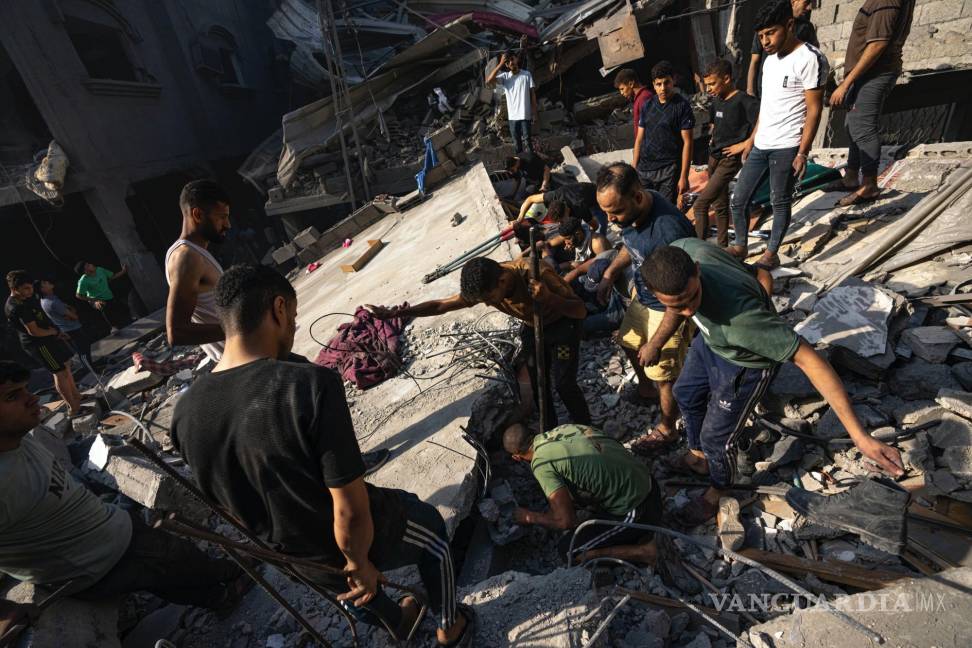 $!Palestinos buscan cadáveres y sobrevivientes entre los restos de un edificio residencial arrasado tras un ataque aéreo israelí sobre el campo de refugiados.