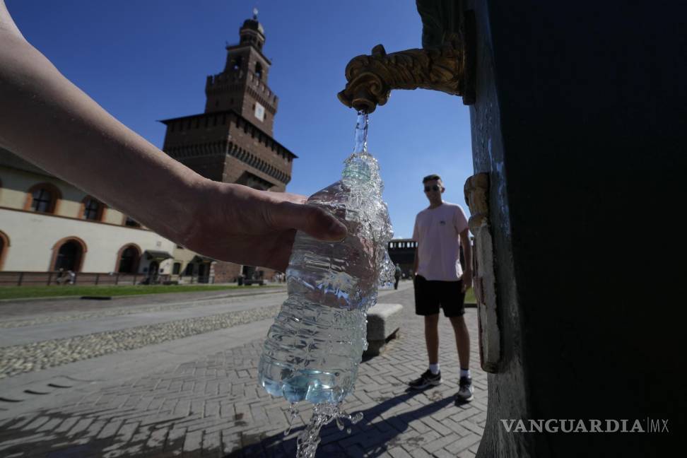 $!Turistas rellenan botellas de plástico con agua de un bebedero público en el Castillo de Sforzesco, el 25 de junio de 2022, en Milán.