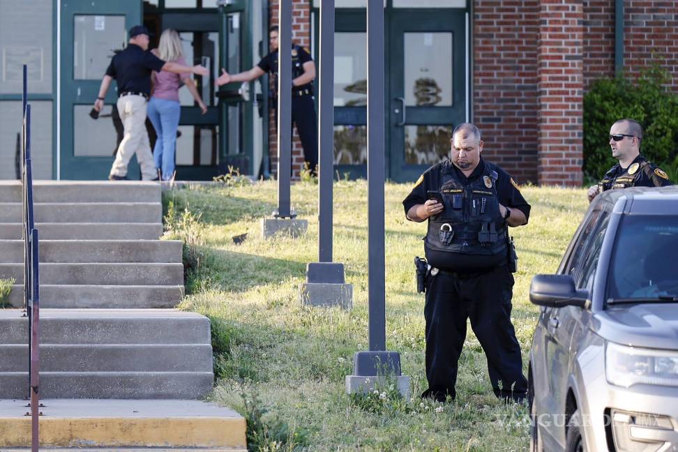 $!Policías afuera de la escuela secundaria Henryetta, cuando la gente llega para una vigilia en homenaje a las siete personas encontradas muertas en Okmulgee.