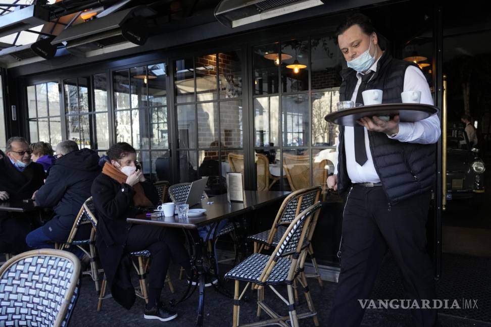 $!Un mesero sirve café en un restaurante en París. AP Photo/Thibault Camus