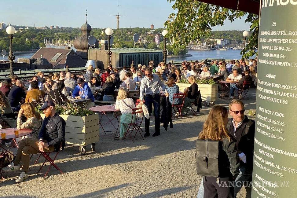 $!People enjoy drinks and snacks in the evening sun on a terrace overlooking Stockholm, Tuesday, May 30, 2023. Smoking is prohibited in both indoor and outdoor areas of bars and restaurants in Sweden, which has the lowest share of smokers in the European Union. (AP Photo/Karl Ritter)