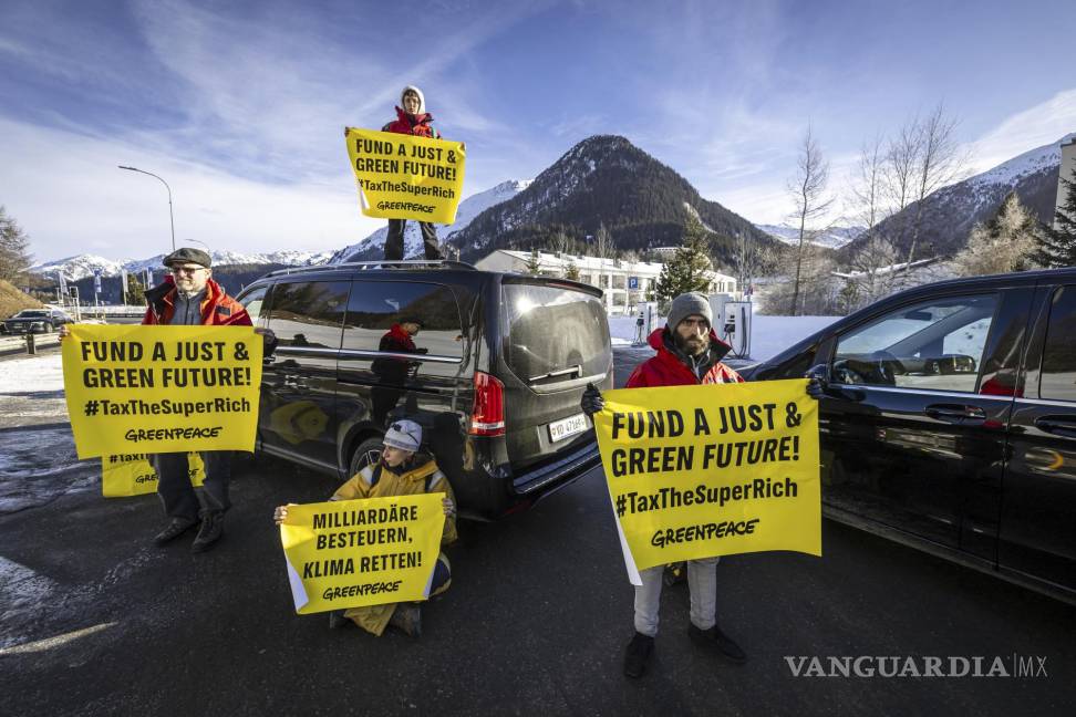 $!Activistas de Greenpeace bloquean el camino de acceso al helipuerto durante una protesta en Davos Dorf durante la 55ª reunión anual del Foro Económico Mundial.