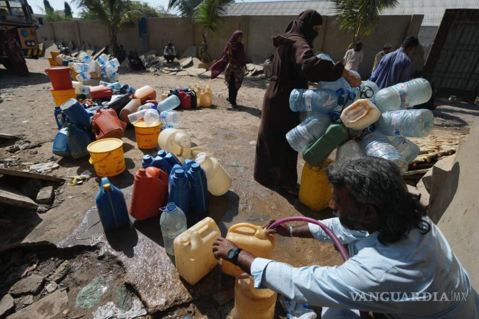 $!Gente recogiendo agua de un punto de suministro en una barriada de Karachi, Pakistán, el martes 21 de marzo de 2023.