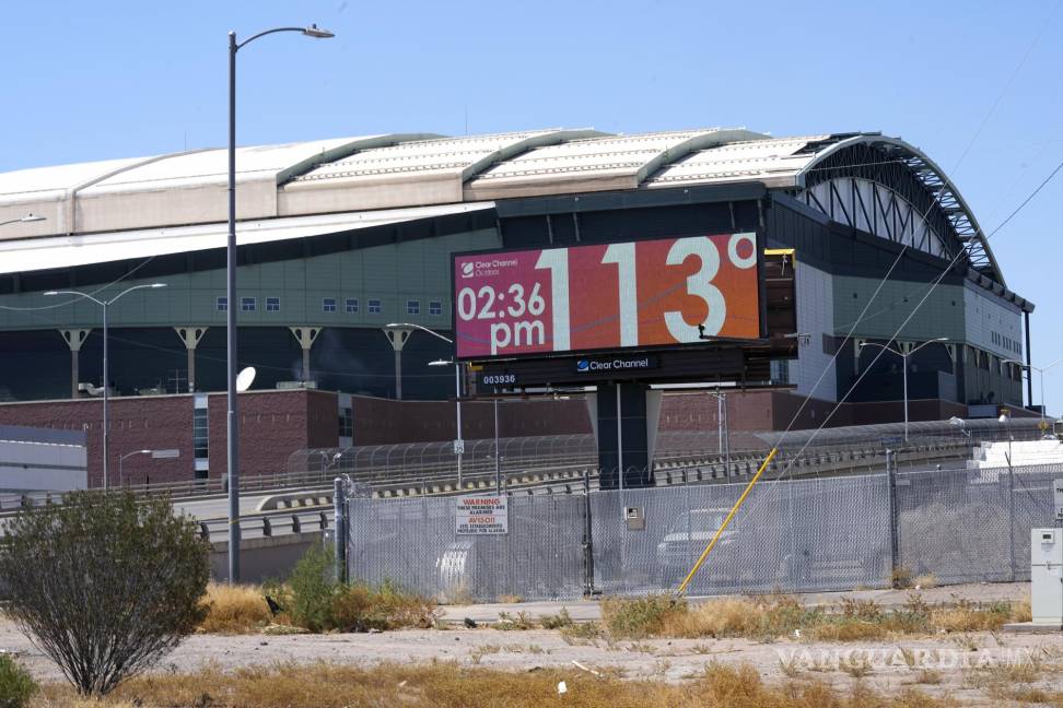 $!Con Chase Field, sede del equipo de béisbol Arizona Diamondbacks de fondo, un letrero digital actualiza la hora y la temperatura en Phoenix