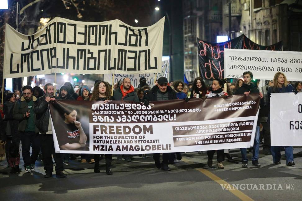 $!Manifestantes sostienen pancartas pidiendo la liberación de la periodista encarcelada Mzia Amaghlobeli mientras marchan por las calles de Tbilisi, Georgia.