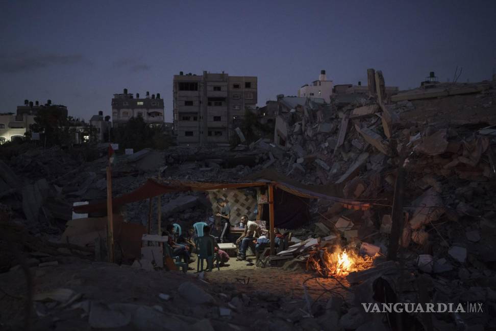 $!Una familia se sienta en una carpa improvisada entre los escombros de su casa, destruida por un ataque aéreo en Beit Lahiya, en el norte de la Franja de Gaza, el lunes 14 de junio de 2021. AP/Felipe Dana
