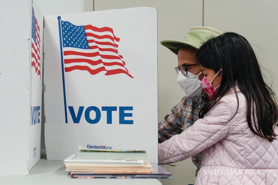 $!Una persona marca su boleta mientras su hijo observa en el lugar de votación en la Biblioteca Regional Tysons-Pimmit en Falls Church, Virginia.