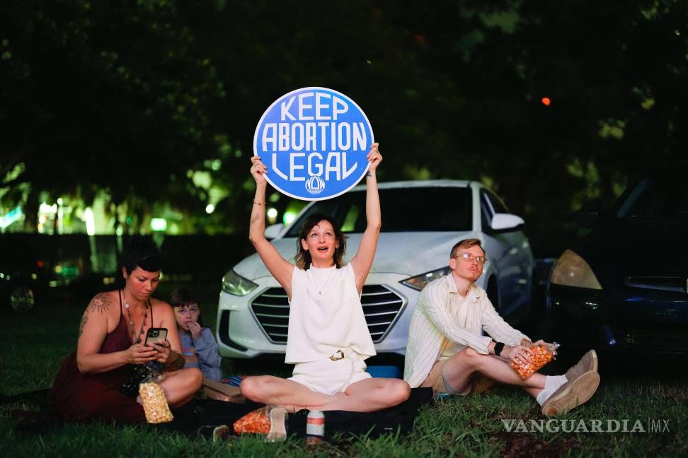 $!La defensora de los derechos reproductivos Kat Duesterhaus con un cartel mientras Joe Biden y Donald Trump, hablan sobre el acceso al aborto. en Miami