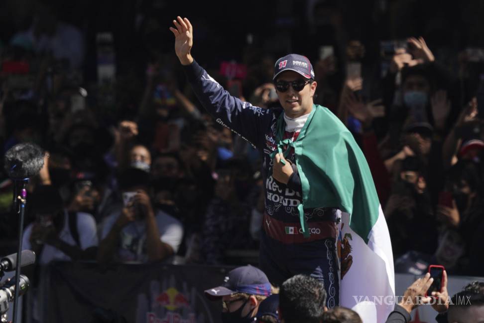 $!El piloto mexicano Sergio Pérez saluda al público durante una exhibición con su monoplaza Red Bull en el Paseo de la Reforma, previo al Gran Premio de México. AP/Fernando Llano