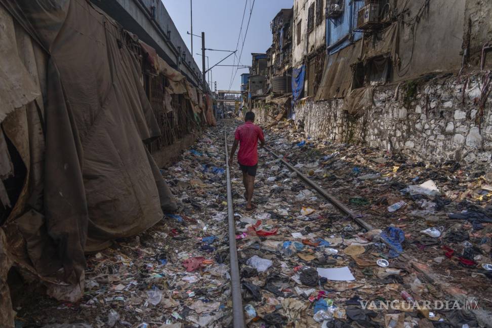 $!Un hombre camina en una vía ferroviaria repleta de plásticos y otros desechos en el Día de la Tierra, en Mumbai, India, el 22 de abril de 2024.