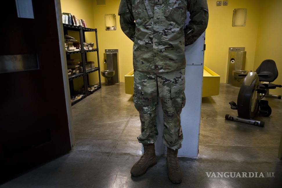 $!Un soldado estadounidense se encuentra entre dos celdas, una utilizada como biblioteca y la otra como gimnasio en Guantánamo.