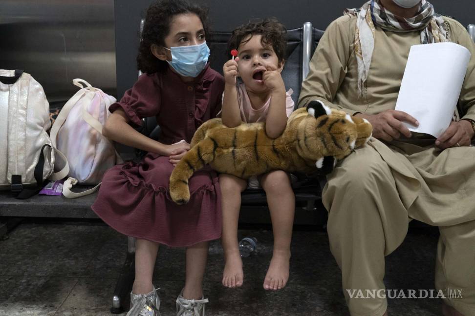 $!Los niños acompañados por su familia evacuados de Kabul, Afganistán, se sientan en la terminal antes de abordar un autobús después de llegar al Aeropuerto Internacional Washington Dulles, en Chantilly, Virginia. AP/Jose Luis Magana