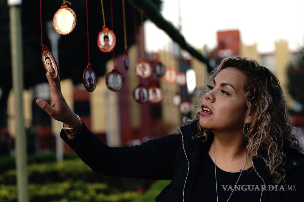 $!Una mujer toca un adorno navideño con la imagen de un ser querido desaparecido en el Jardín Memorial. AP/Marco Ugarte