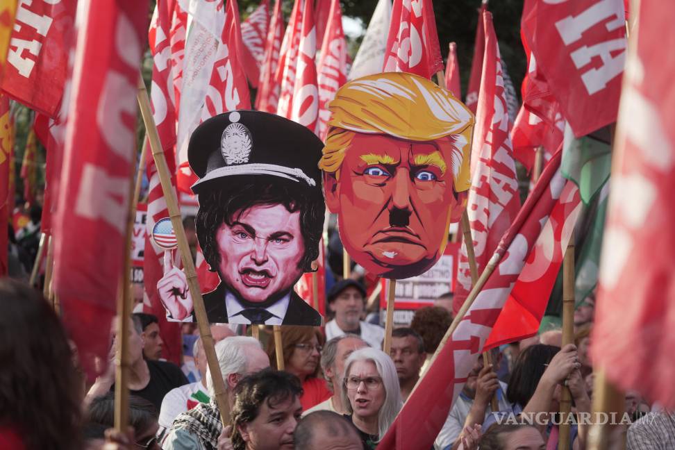 $!Manifestantes antigubernamentales sostienen carteles que satirizan a Donald Trump y Javier Milei frente a la Embajada de Estados Unidos en Buenos Aires.