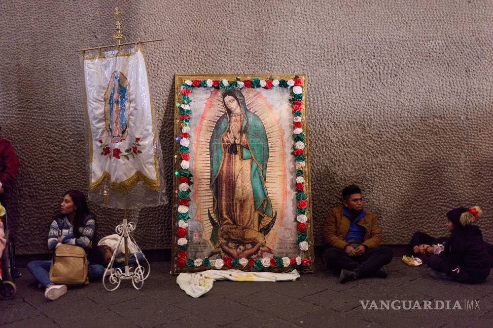 $!Peregrinos descansan junto a una imagen de la Virgen de Guadalupe en el exterior de su basílica, en la Ciudad de México, el 11 de diciembre de 2025.