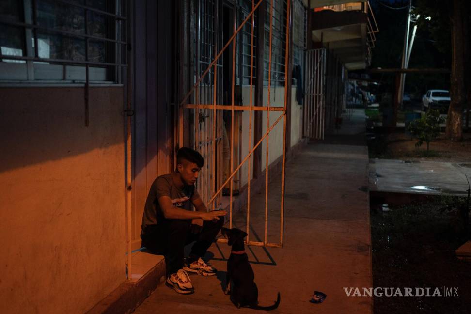 $!Un estudiante juega con su perro fuera de su cuarto en la escuela Normal Rural Raúl Isidro Burgos, en Ayotzinapa, en el estado de Guerrero.