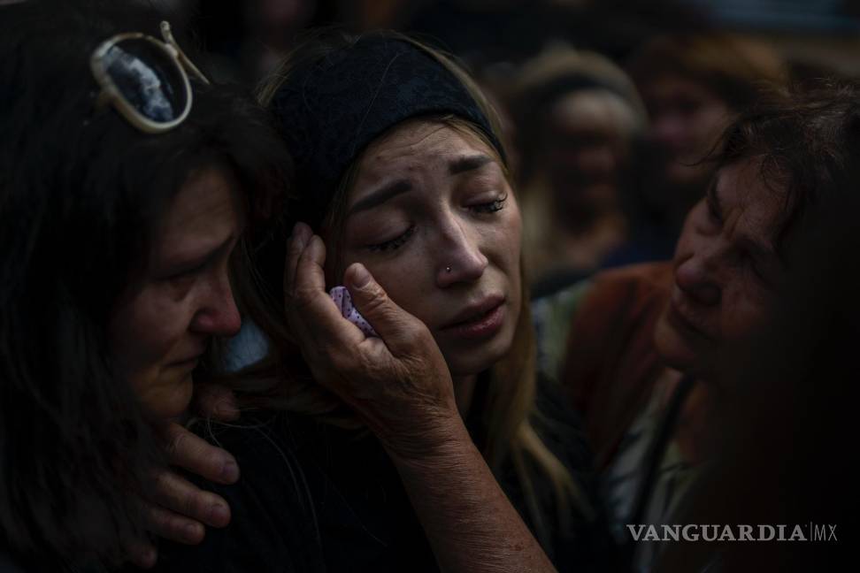 $!Anastasia Ohrimenko es consolada por sus familiares mientras llora junto al féretro de su esposo durante su funeal, en Bucha, Ucrania, el 31 de agosto de 2022.