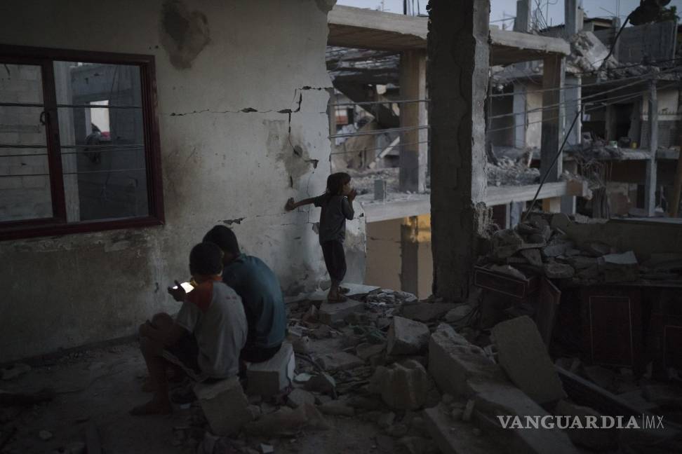 $!Chadi Nassir, de 7 años, mira desde una habitación mientras dos de sus hermanos juegan a videojuegos en su casa, muy dañada por los ataques aéreos en Beit Hanoun, en el norte de la Franja de Gaza, el viernes 11 de junio de 2021. AP/Felipe Dana