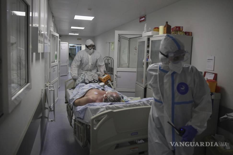 $!Personal médico con trajes protectores trasladan a un paciente con COVID-19 en una unidad de cuidado intensivo en el Hospital Clínico Regional 1 en Krasnodar, Rusia. AP/Vitali Timkiv