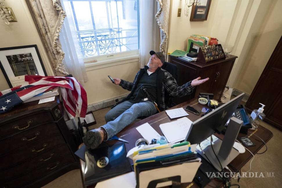 $!Un partidario del ex presidente de Donald Trump, se sienta en el escritorio de la presidenta de la Cámara de Representantes Nancy Pelosi. EFE/EPA/Jim Lo Scalzo