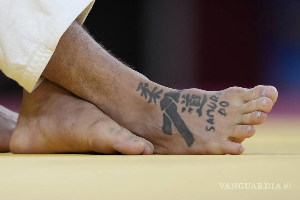 $!Un tatuaje con los personajes de “Judo” se puede ver en el pie de Peter Paltchik de Israel, a la izquierda, durante su ronda de cuartos de final masculina de -100 kg | (AP Photo / Vincent Thian)