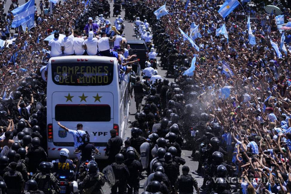 $!La selección argentina de fútbol muestra su trofeo de la Copa del Mundo desde un autobús cuando son recibidos en Buenos Aires, Argentina.