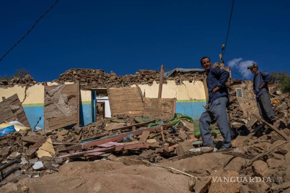 $!Brahim Bel Haj, izquierda, y su hermano Mohammed, de pie entre los escombros de la casa familiar en el pueblo marroquí de Ida Um Dostadud, Marruecos.