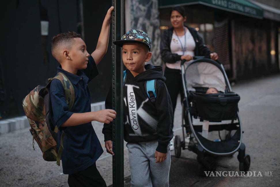 $!La inmigrante ecuatoriana Kimberly Carchipulla, derecha, y su hijo Damien, al centro, aguardan el autobús en su camino a la escuela en Nueva York.