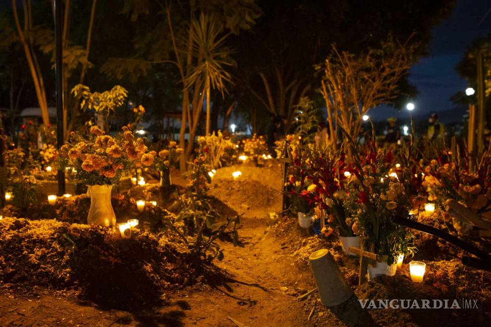 $!Este lunes 1 de noviembre de 2021, las personas acuden al Panteón Atzompa, Oaxaca, para adornar con flores, veladoras y comida a las tumbas de sus familiares difuntos por la tradición de Día de Muertos. Agencia EL UNIVERSAL/RDB