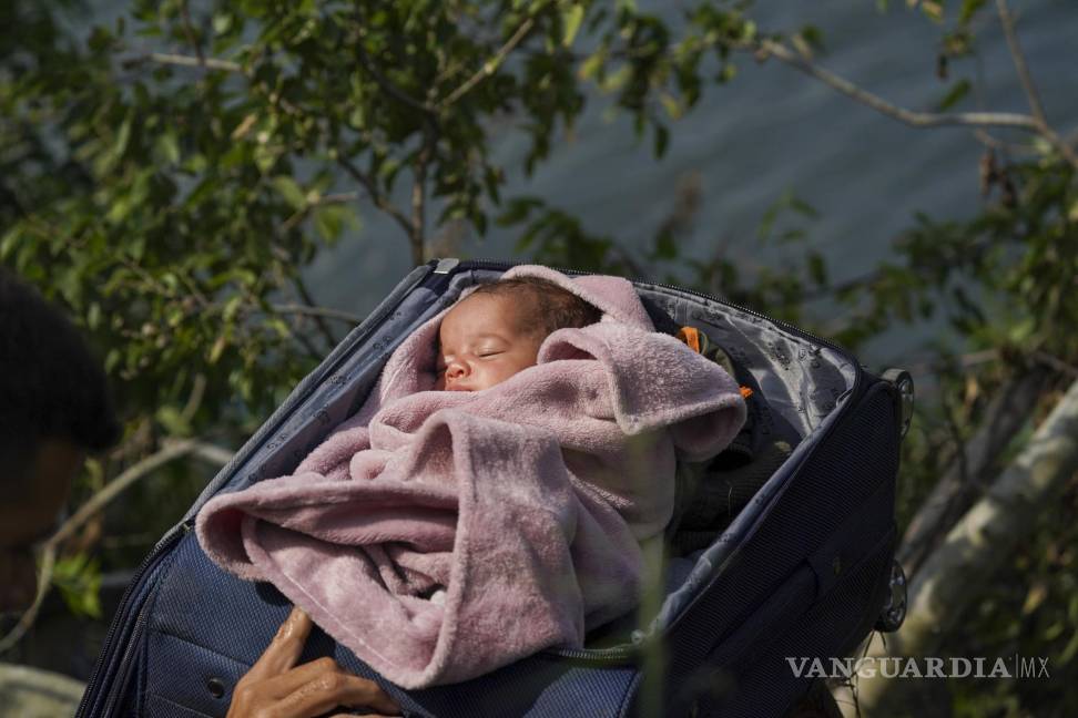 $!Migrantes cruzan el Río Bravo para entrar a Estados Unidos, con un bebé dentro de una maleta, vistos desde Matamoros, México, el 10 de mayo de 2023.