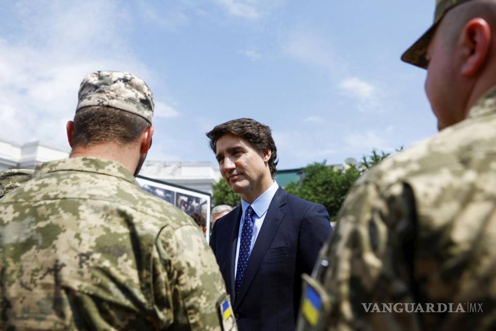 $!El primer ministro canadiense, Justin Trudeau, habla con soldados ucranianos mientras visita el Muro del Recuerdo, en Kiev, Ucrania.