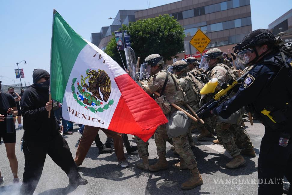 $!Un manifestante con un bandera mexicana se enfrenta a las autoridades durante una protesta tras los operativos migratorios en Los Ángeles.