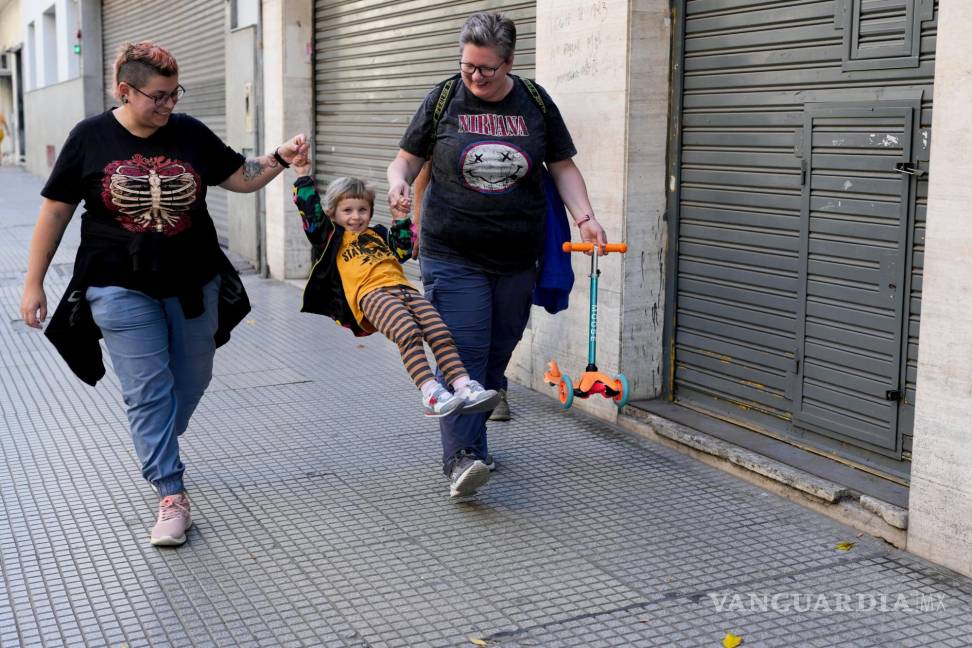 $!Anastasia Domini, a la izquierda, y su esposa, Anna, se dirigen con su hija a un parque en Buenos Aires, Argentina.
