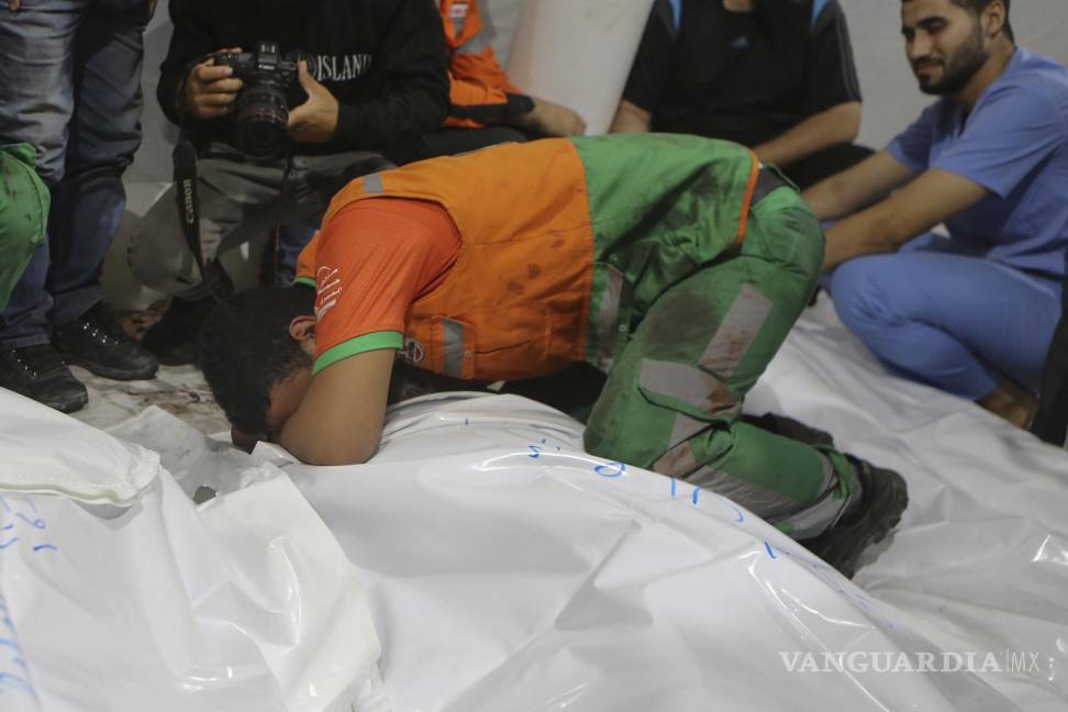 $!Elementos de protección civil palestinos lloran por la muerte de uno de sus colegas durante un bombardeo israelí.