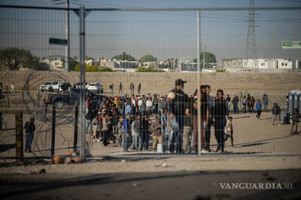 $!Migrantes hacen fila en un campamento de migrantes para ser registrados por agentes de la Patrulla Fronteriza antes de ser procesados en El Paso, Texas.