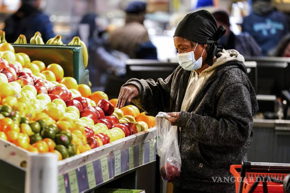 $!Una compradora con mascarilla selecciona frutas en el Reading Terminal Market en Filadelfia. AP/Matt Rourke