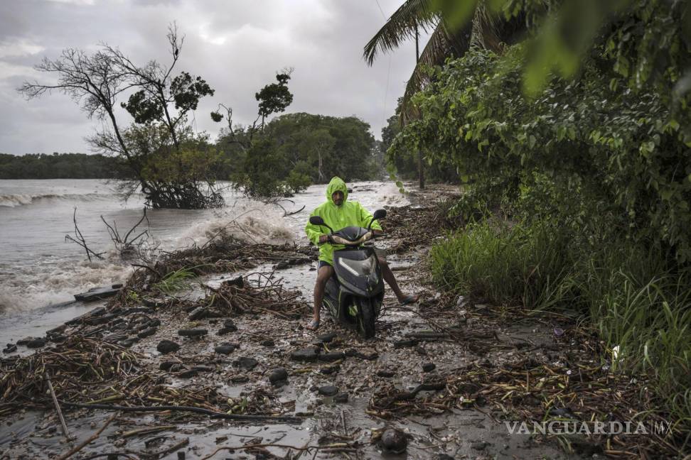 $!Delmer Torres conduce su motocicleta por una carretera cubierta por escombros en su comunidad costera de El Bosque, en el estado de Tabasco, México.