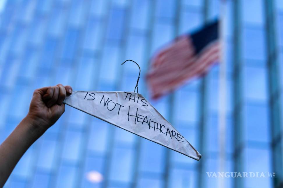 $!Una mujer sostiene un gancho de ropa para simbolizar los abortos ilegales y peligrosos en una protesta en pro del derecho en Los Ángeles.