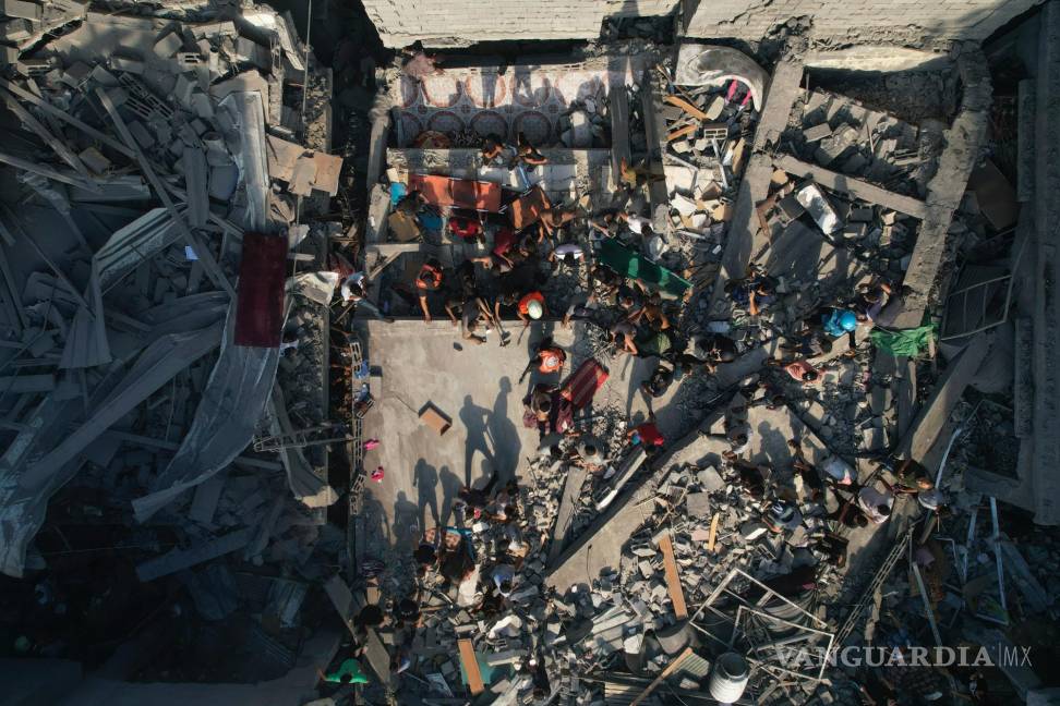 $!Palestinos inspeccionan los escombros de edificios alcanzados por un ataque aéreo israelí en el campo de refugiados Al Shati, el 12 de octubre de 2023.