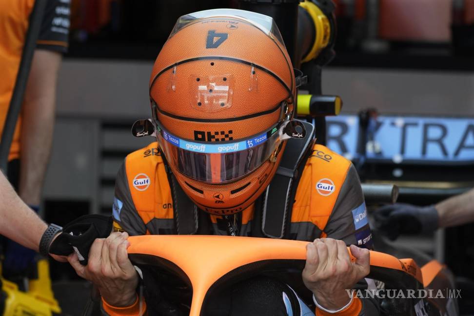 $!El piloto de McLaren, Lando Norris sale de su automóvil con un casco pintado como una pelota de baloncesto después de la primera sesión de práctica.