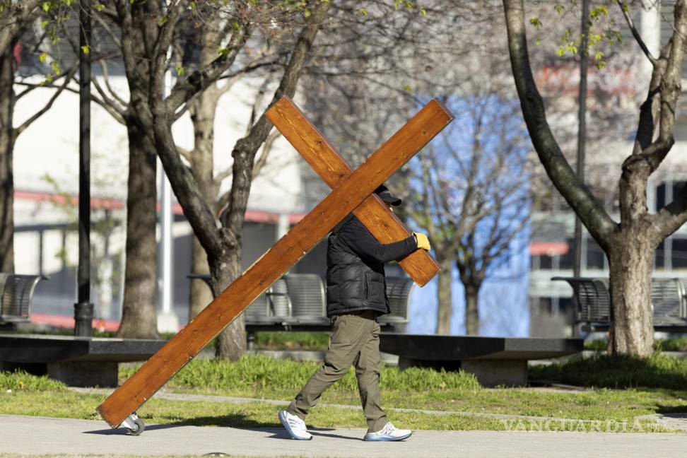 $!Dan Beazley de Michigan camina con una cruz antes de una vigilia realizada por las víctimas del tiroteo en The Covenant School en Nashville, Tennessee.
