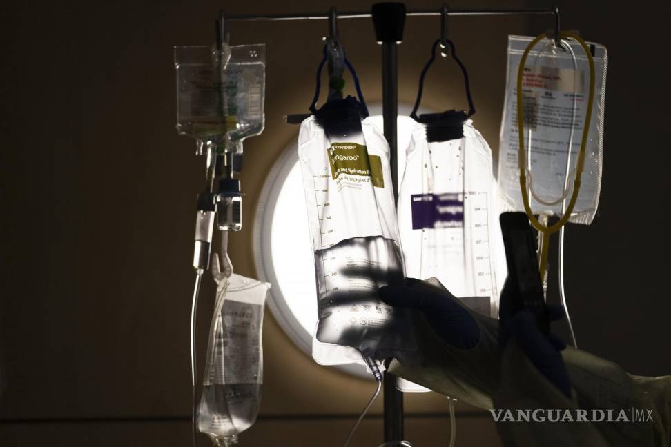 $!Una enfermera revisa los fluidos intravenosos mientras habla con un paciente con COVID-19 en el Centro Médico Providence Holy Cross en Los Ángeles.