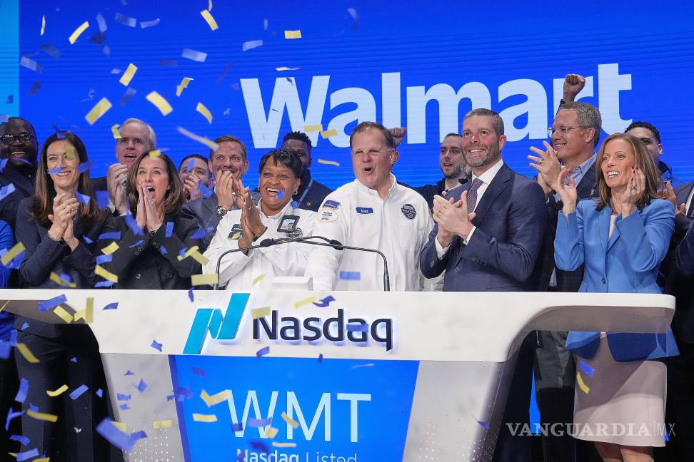 $!Un conductor de Walmart, Mat Brtinmmeier (c) y el director financiero de la compañía, John David Rainey (c-d), toca la campana de apertura en el Nasdaq MarketSite.
