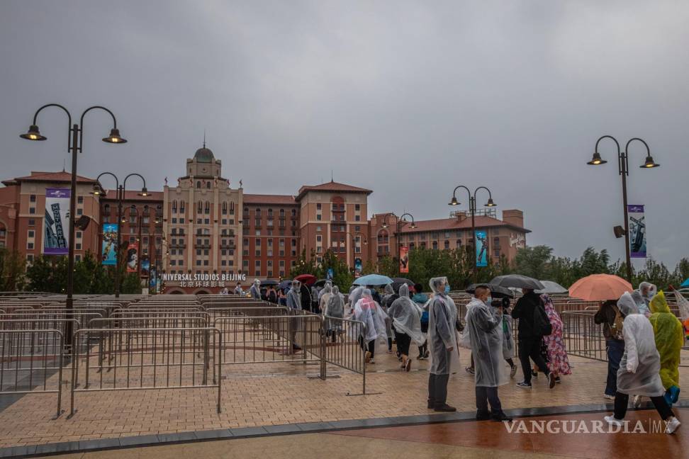 $!Los visitantes caminan bajo la lluvia para ingresar a Universal Studios Beijing el día oficial de la inauguración, en Beijing. EFE/EPA/Roman Pilipey