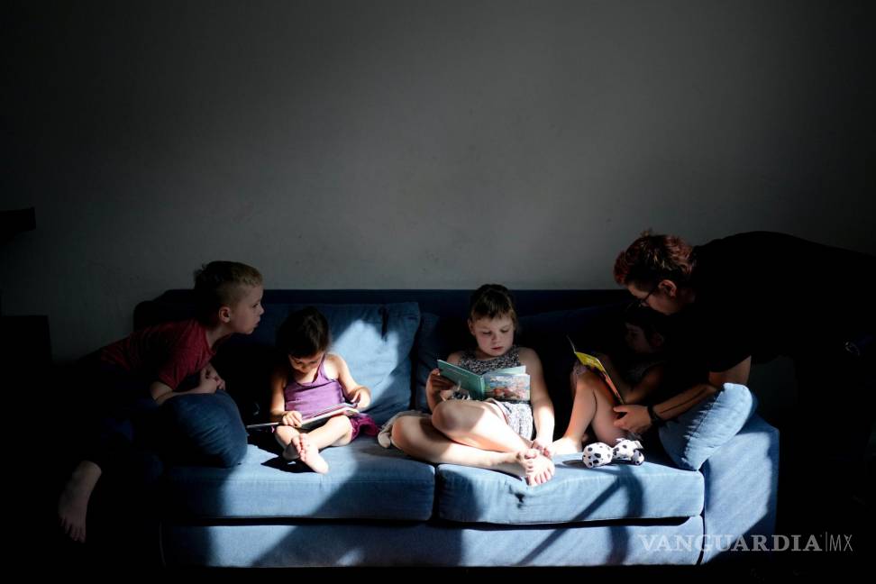 $!Anastasia Domini (d) ayuda a su hija Una a leer, junto a sus hermanos Aksinia, Mikhail y Agata, en su casa de Buenos Aires, Argentina.