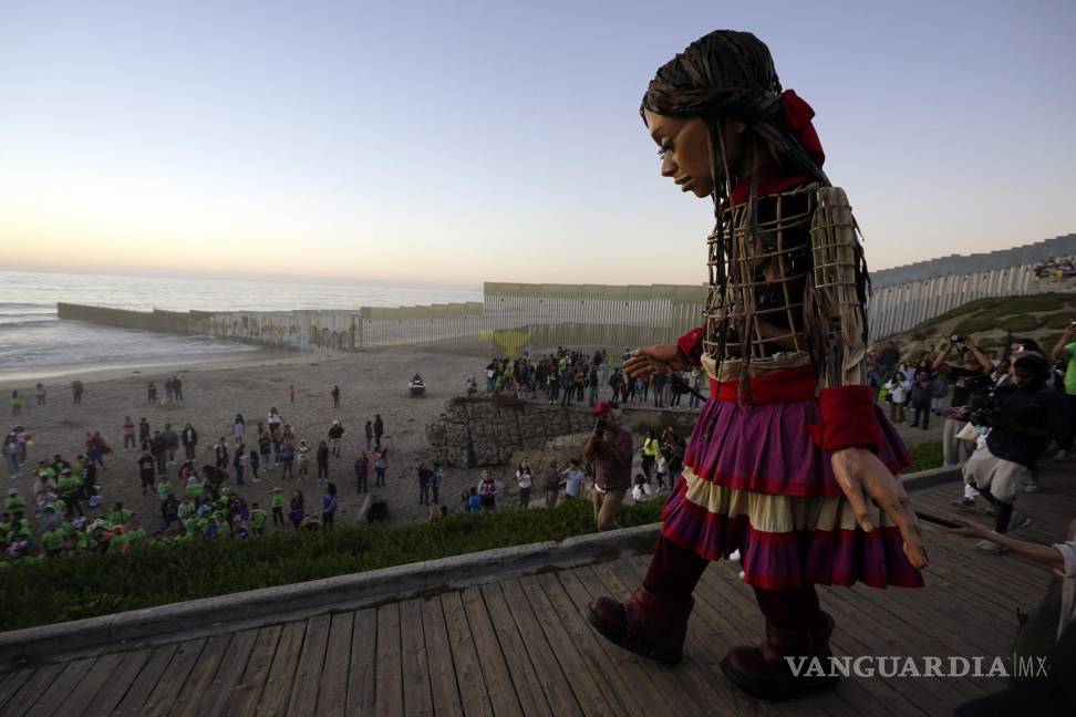 $!La pequeña Amal camina hacia la playa donde el muro fronterizo que divide a Estados Unidos y México en Tijuana.